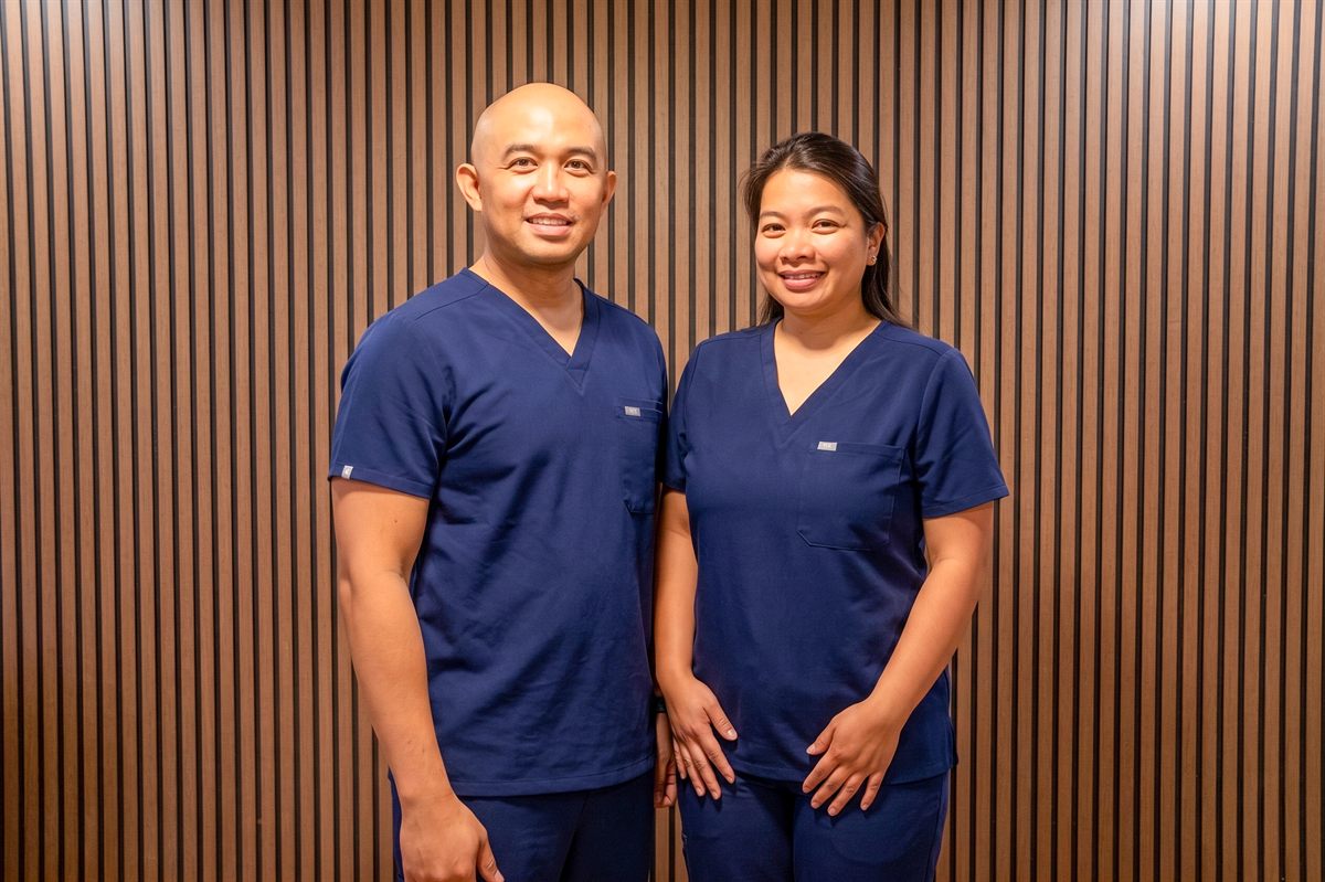 Peter and Cleofe Obaldo, BSN RN — co-owners of Comfort Living, in matching navy scrubs
